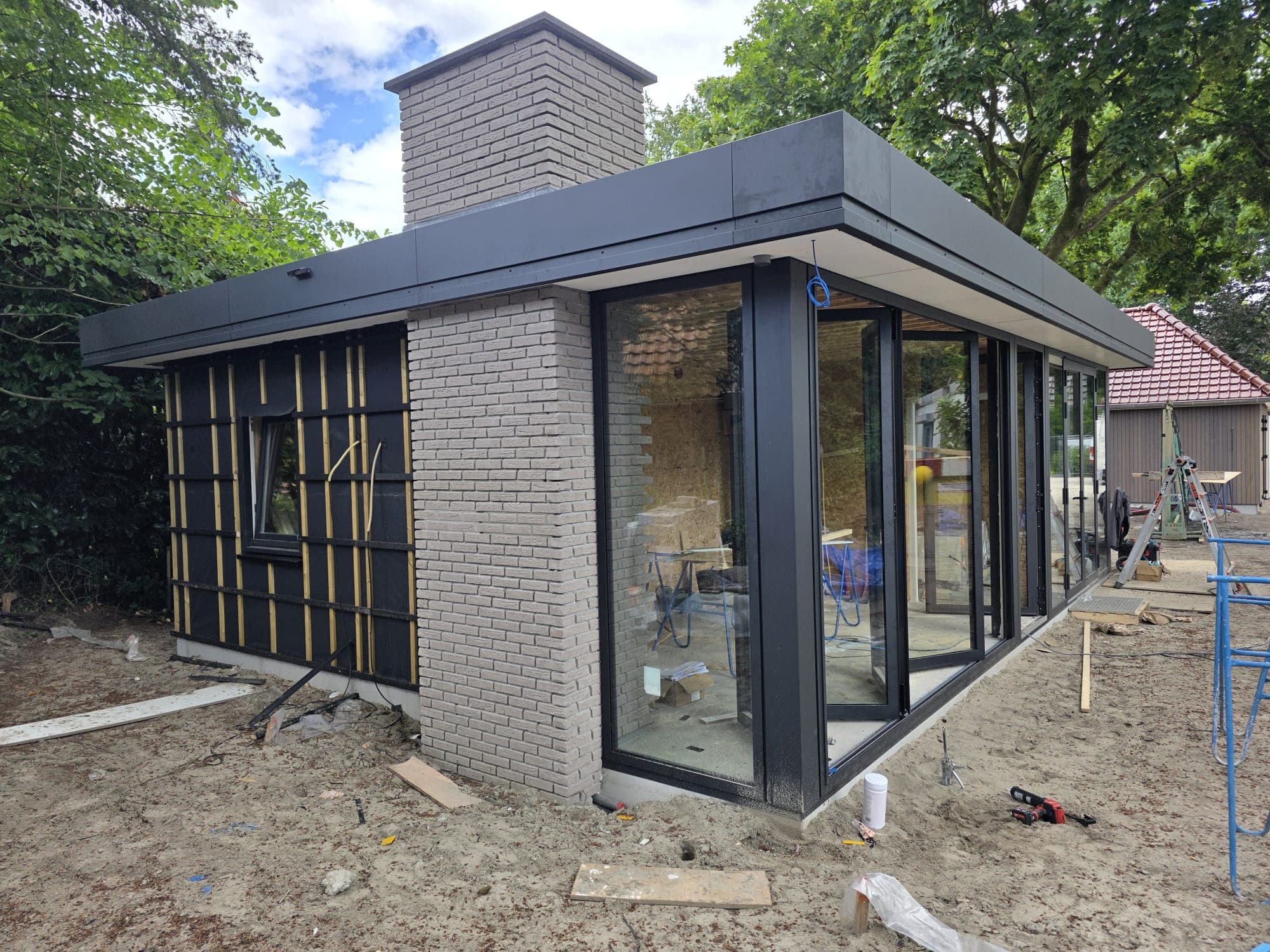 Gemetselde gevel met schoorsteen en aluminium hoekkozijn